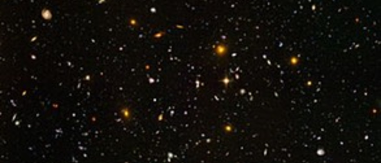 Thousands of small, colorful galaxies are seen on a black background.