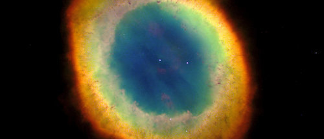 The colors of the vibrant Ring Nebula, its oval shape suspended in the black of space.