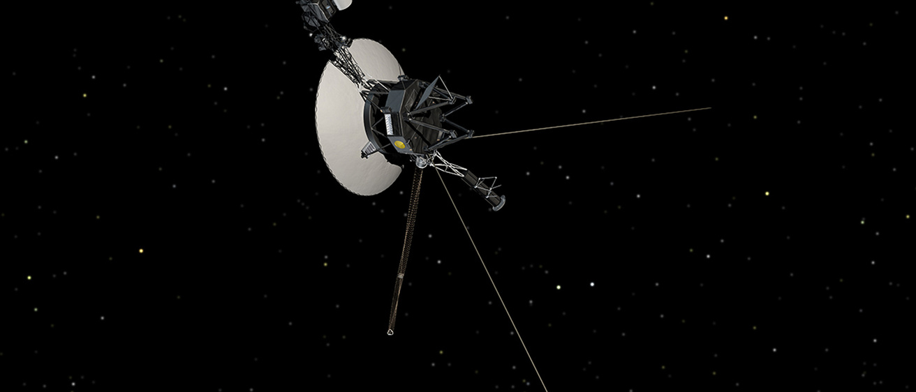 The Voyager 1 spacecraft is shown in space, with a gray metal dinner plate-like dish and extending instruments and antennae.
